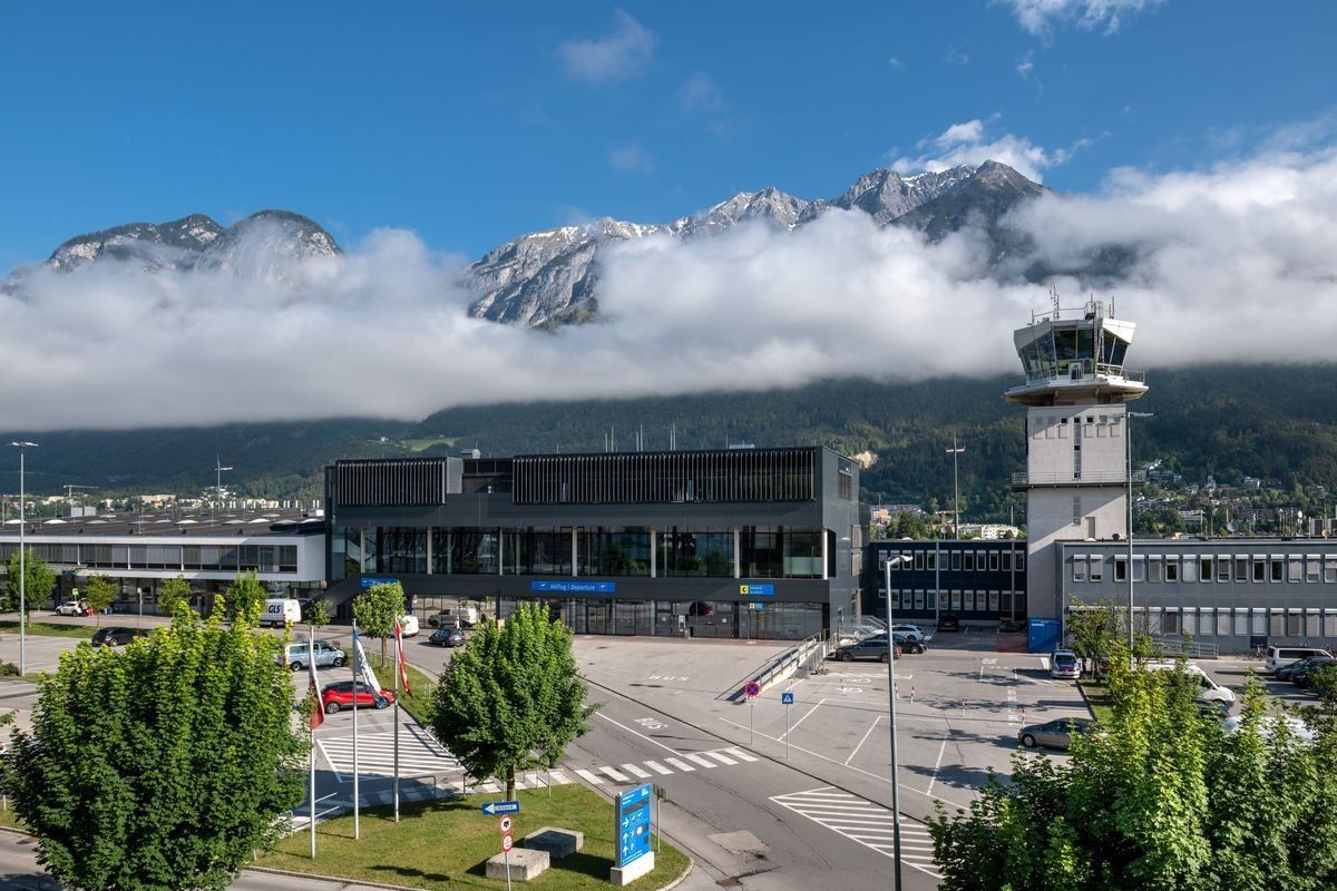 Eine Luftaufnahme eines Flughafens mit Bergen im Hintergrund