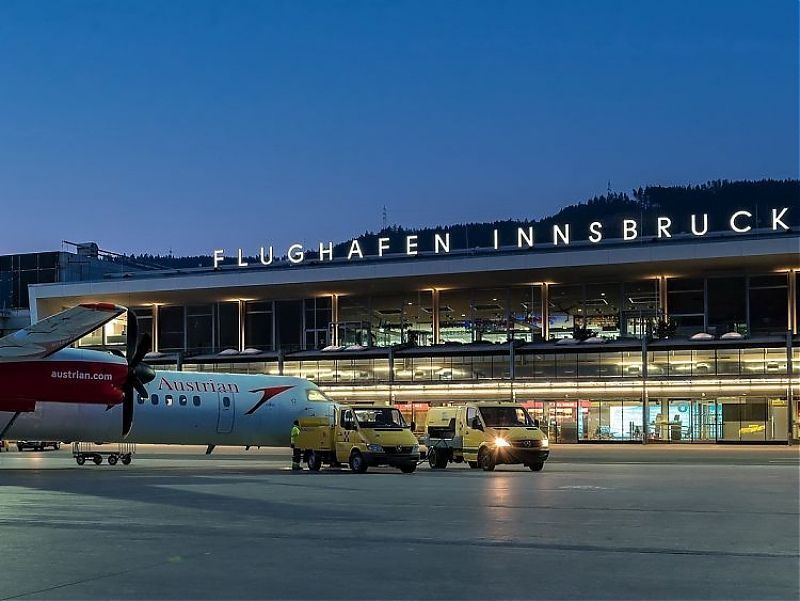 Ein Flugzeug steht vor einem Gebäude mit der Aufschrift „Flughafen Innsbruck“