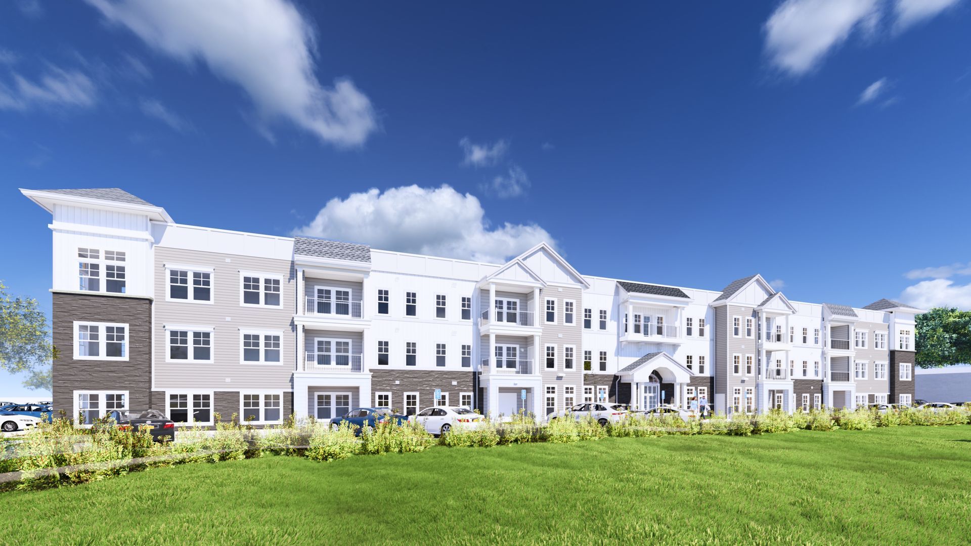 Modern white apartment building with a green lawn under a blue sky