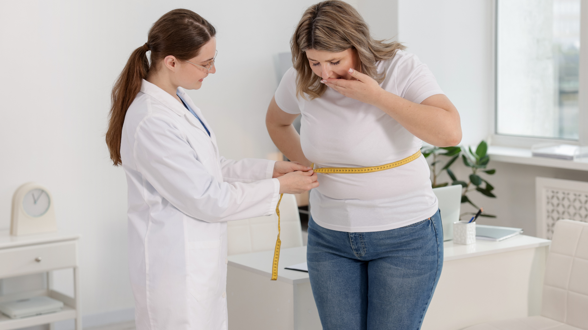 A person wearing athletic clothing measures their waist with a white tape measure.