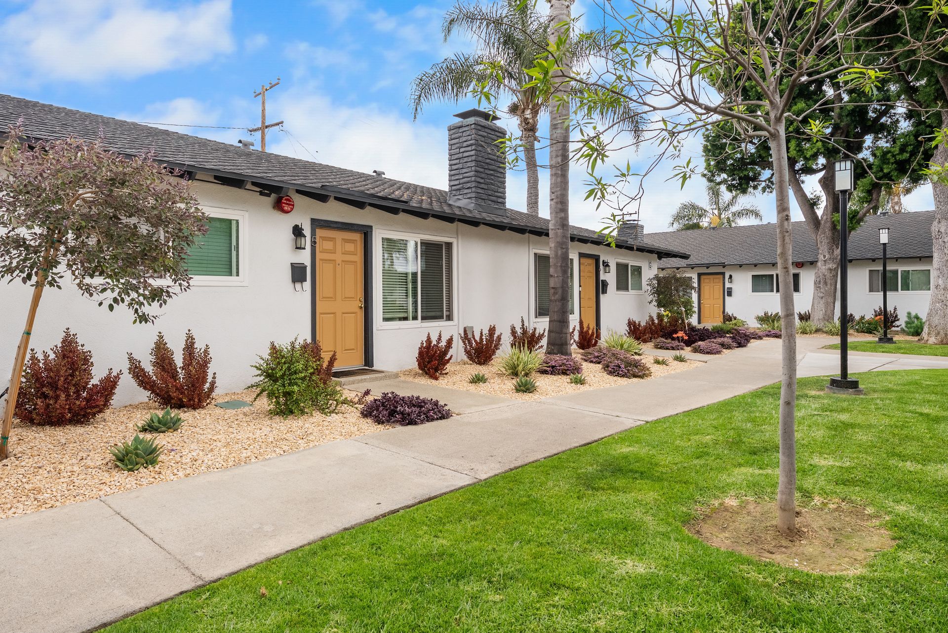 front doors to apartments with grass and landscaping