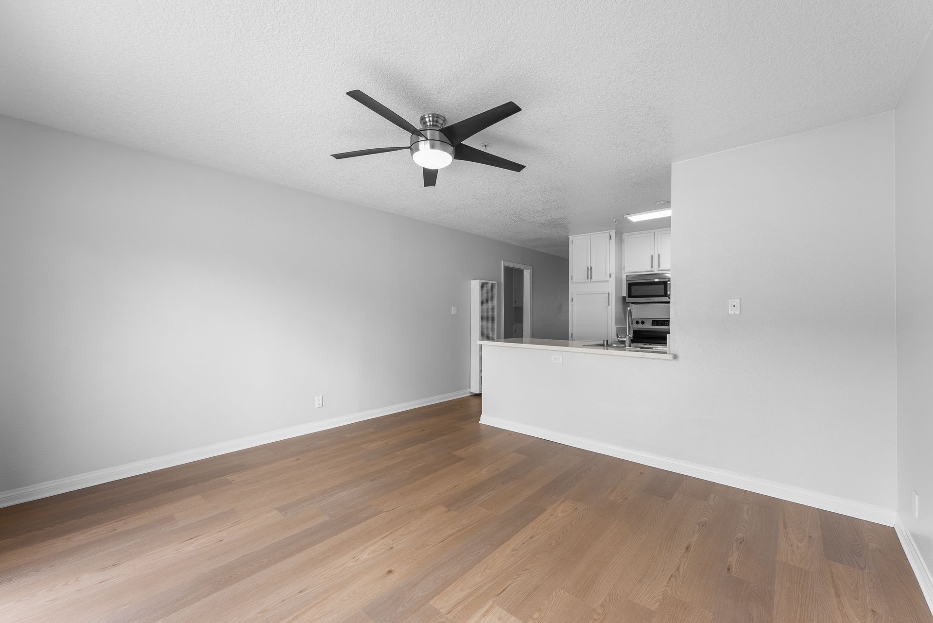interior apartment living space with wood flooring and ceiling fan
