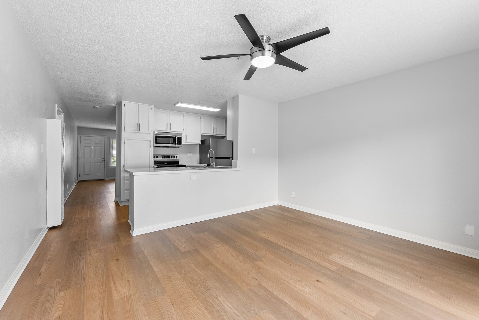 interior apartment living space with wood flooring and ceiling fan