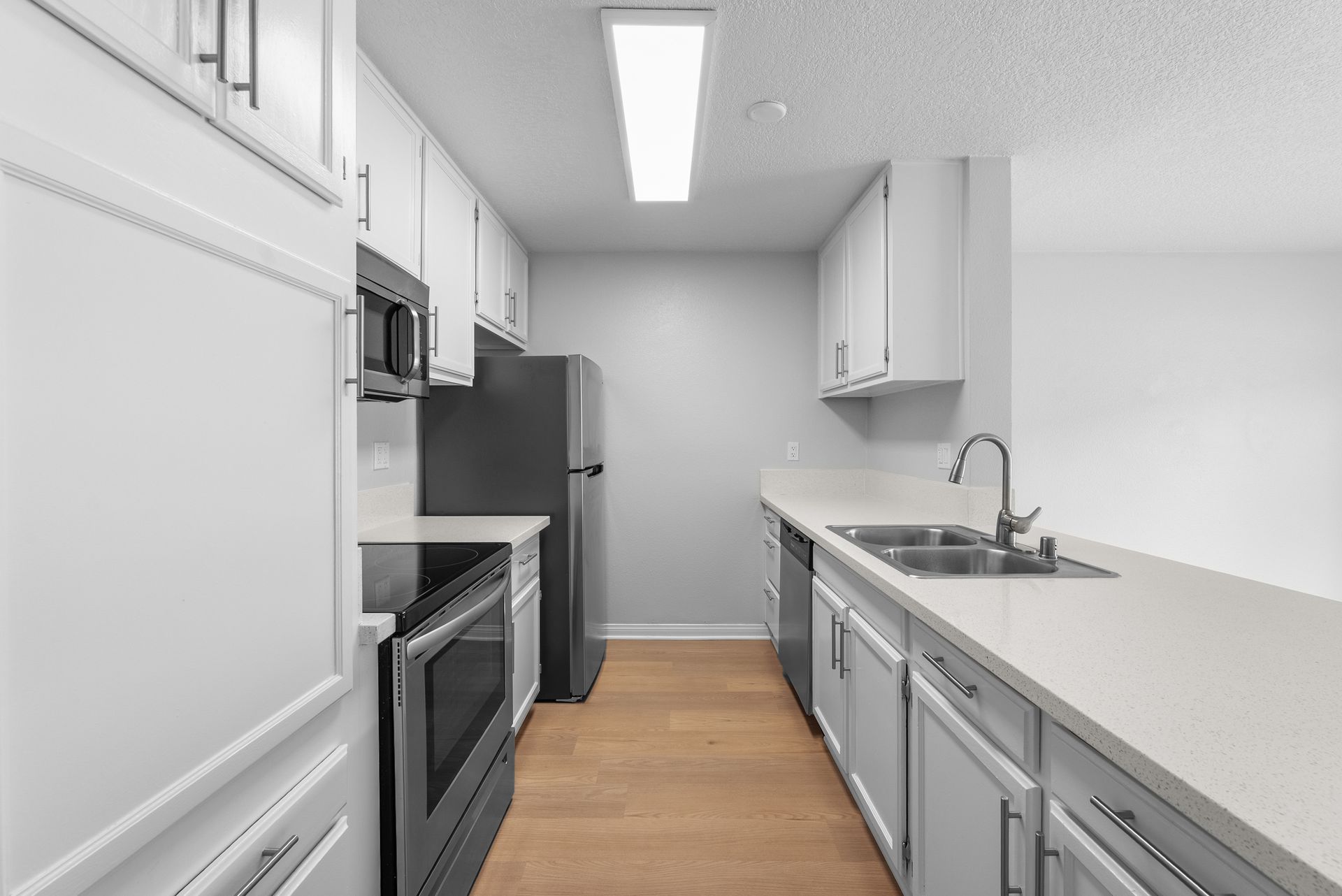 interior apartment living space with kitchen and oven, refrigerator, microwave, and sink