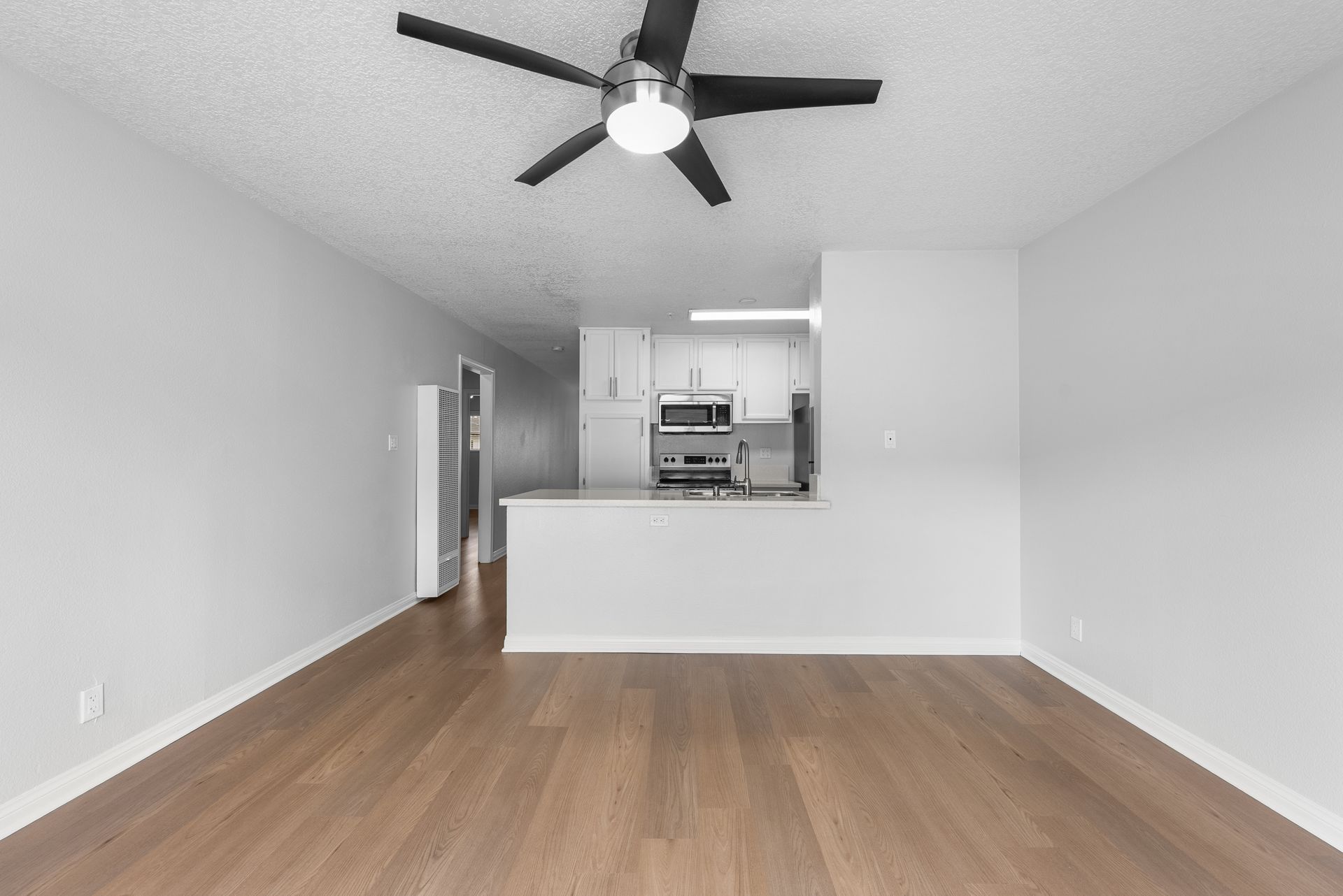 interior apartment living space with wood flooring and ceiling fan