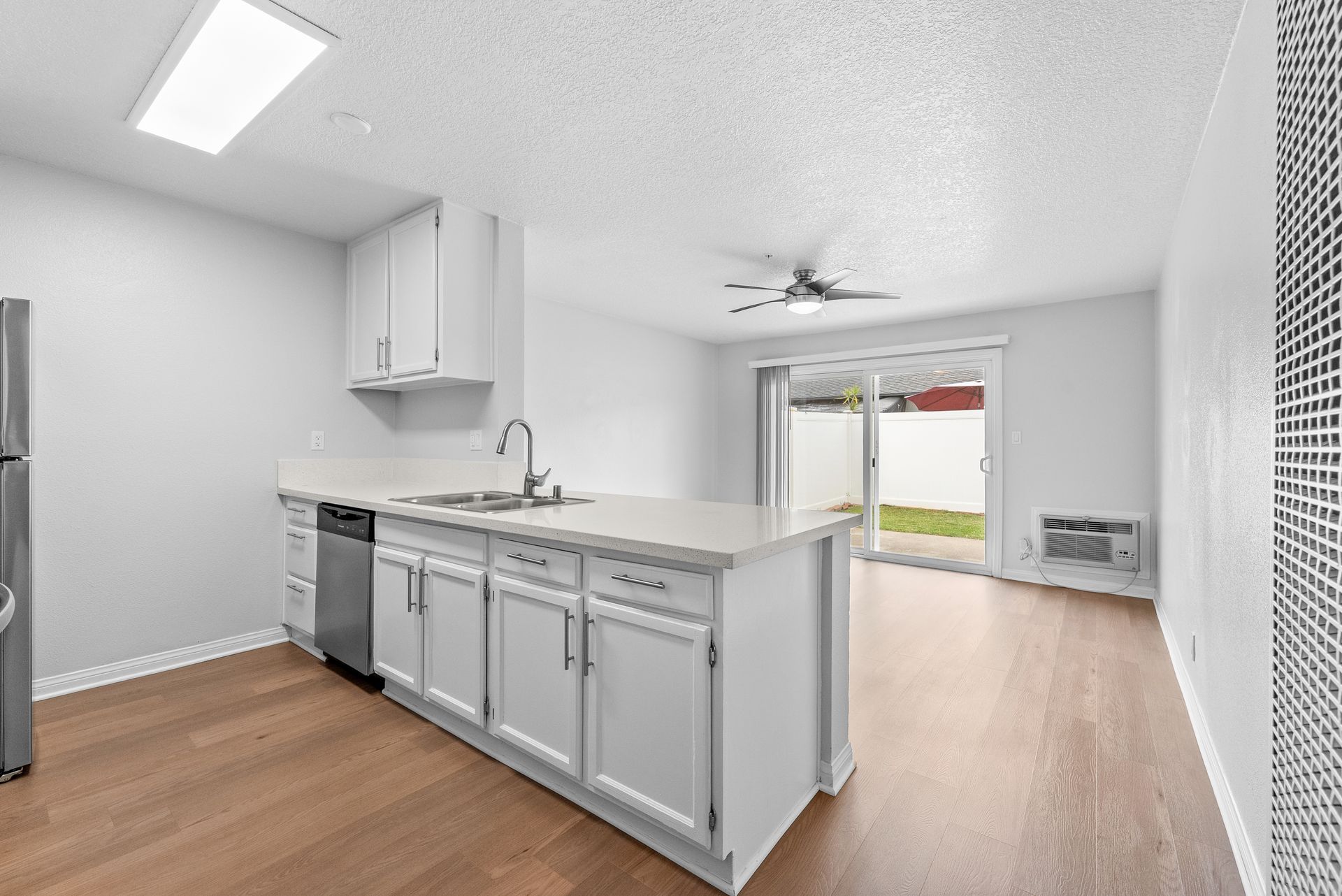 interior apartment living space with kitchen counters, sink, dishwasher, and patio door