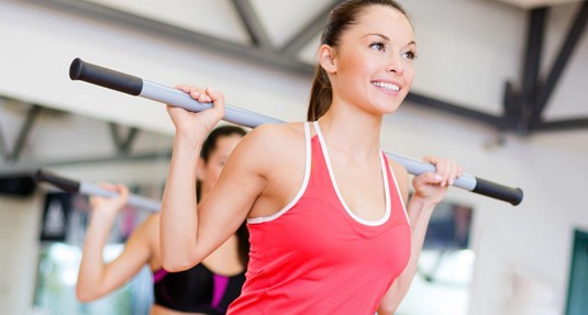 Duas mulheres estão fazendo flexões em uma academia.