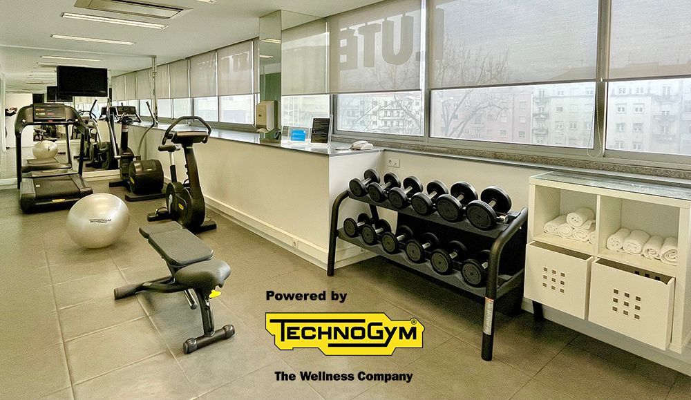 Uma academia com esteira e halteres patrocinada pela technogym