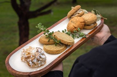 Food truck with three staff, open serving window, menu board, outdoor setting.