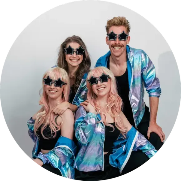 Vier leden van Funky Star Discoshow poseren in blauwe jasjes en stervormige zonnebrillen.