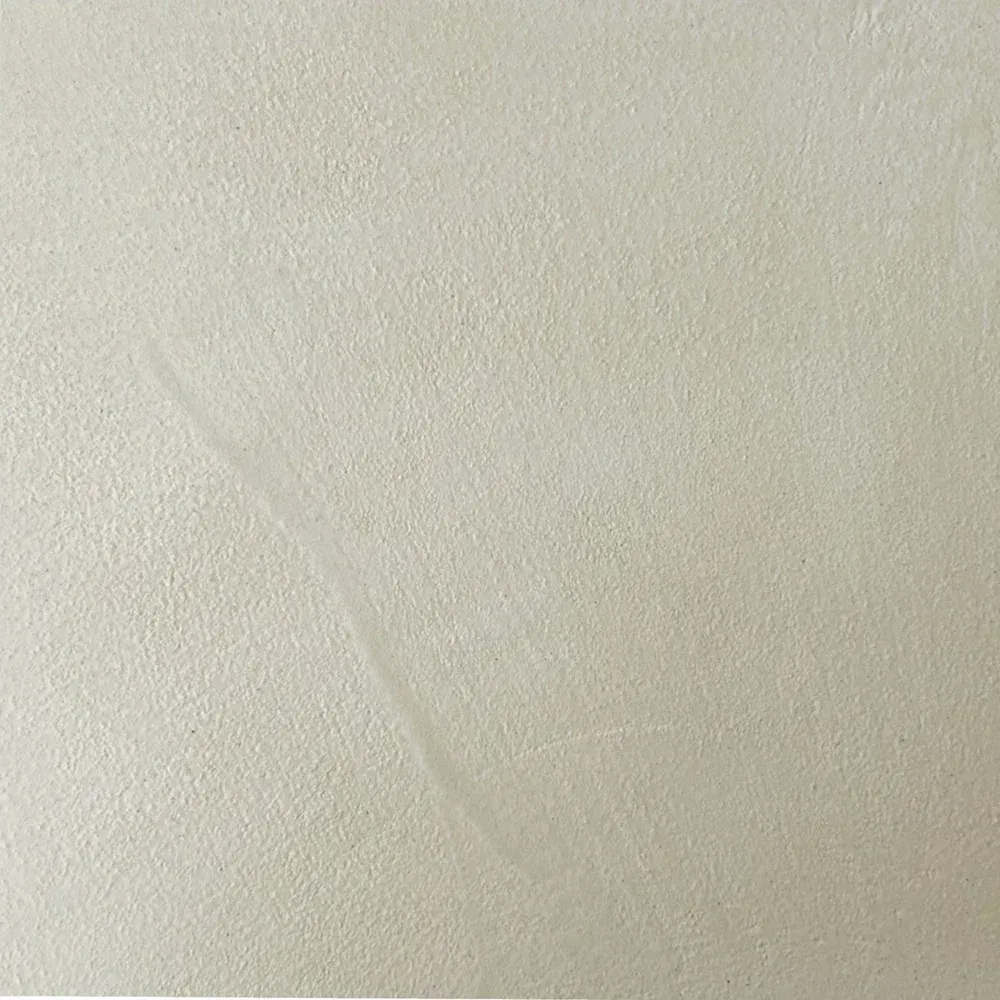 Textured beige wall with a faint, diagonal streak.