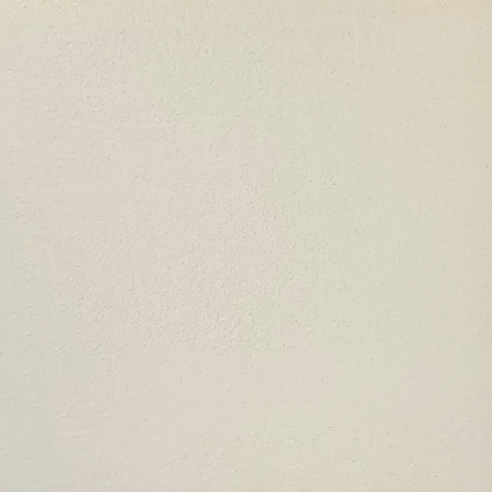 Blank off-white wall with subtle texture and a faint shadow near the bottom edge