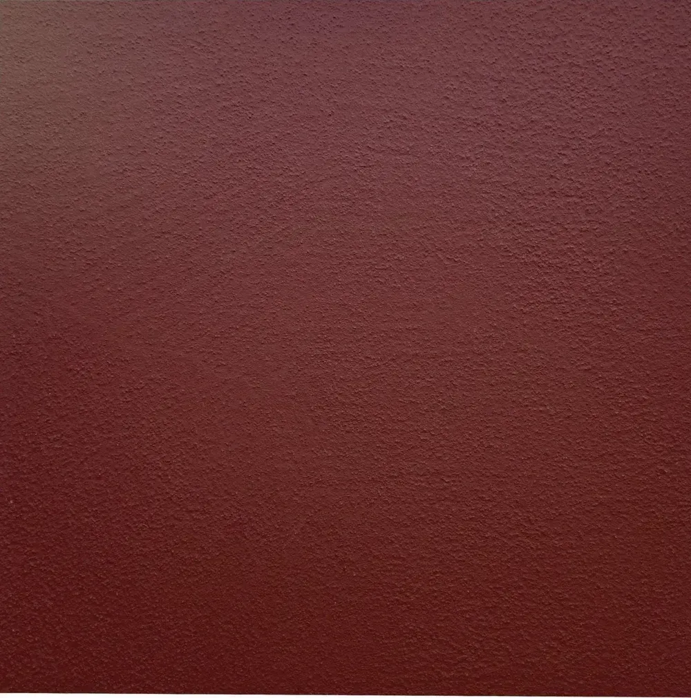 Close-up of a textured dark red surface with a subtle gradient and grainy pattern