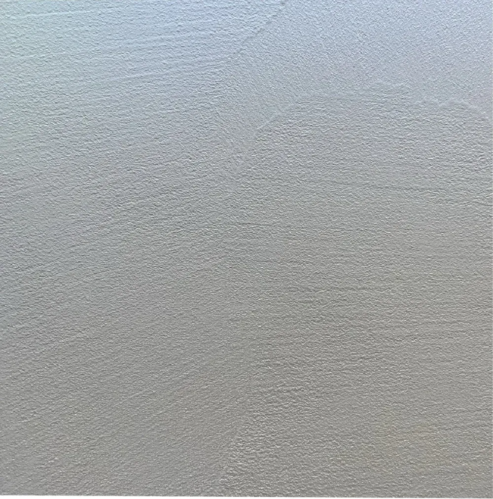 Textured, gray surface with slight gradient, appearing like metal or stone.