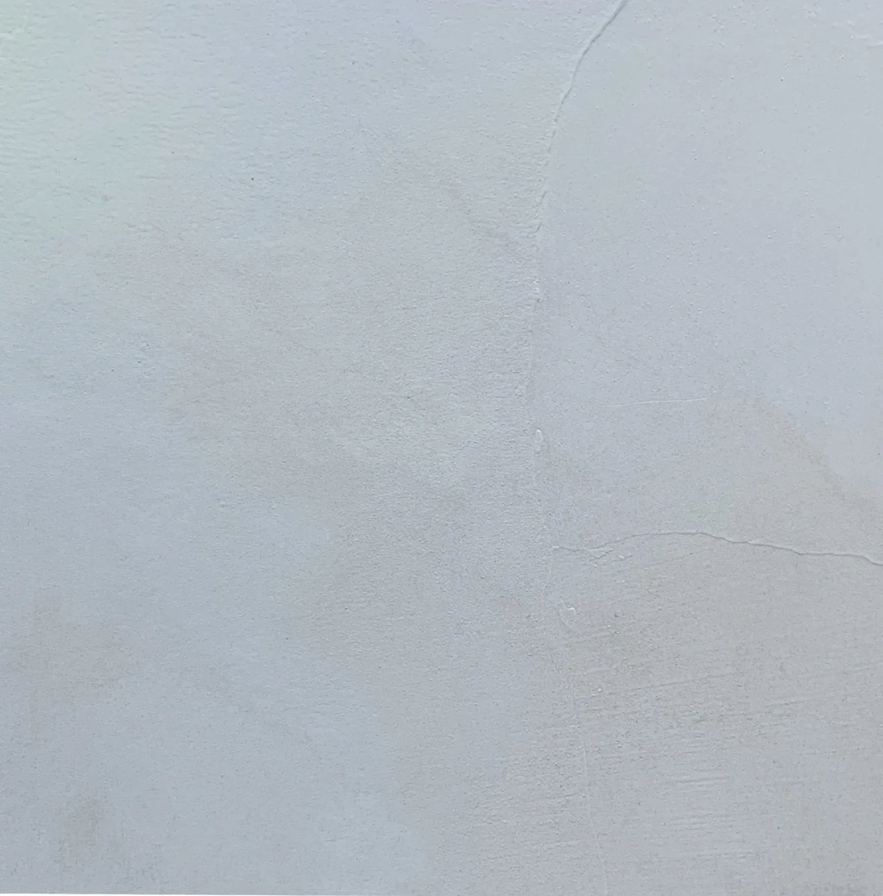 White wall with subtle texture and faint cracks.