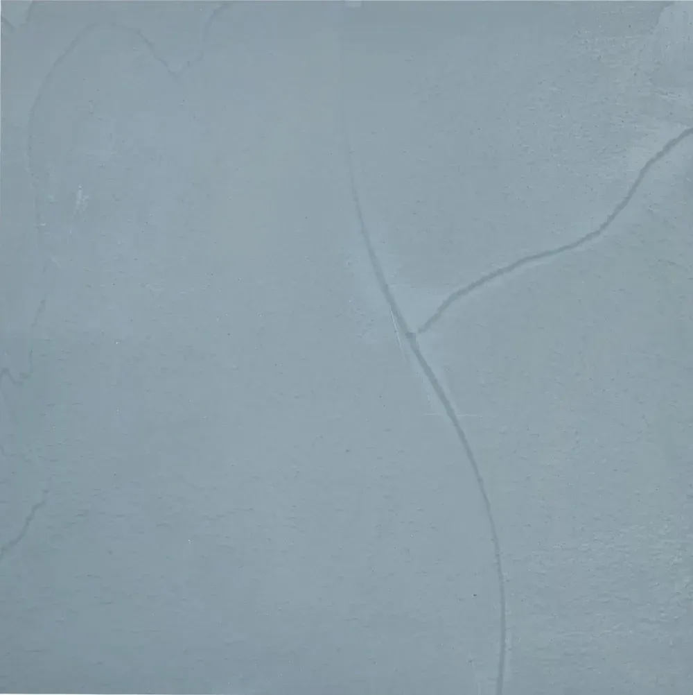 Pale blue textured surface with a subtle crack running diagonally across the right side.
