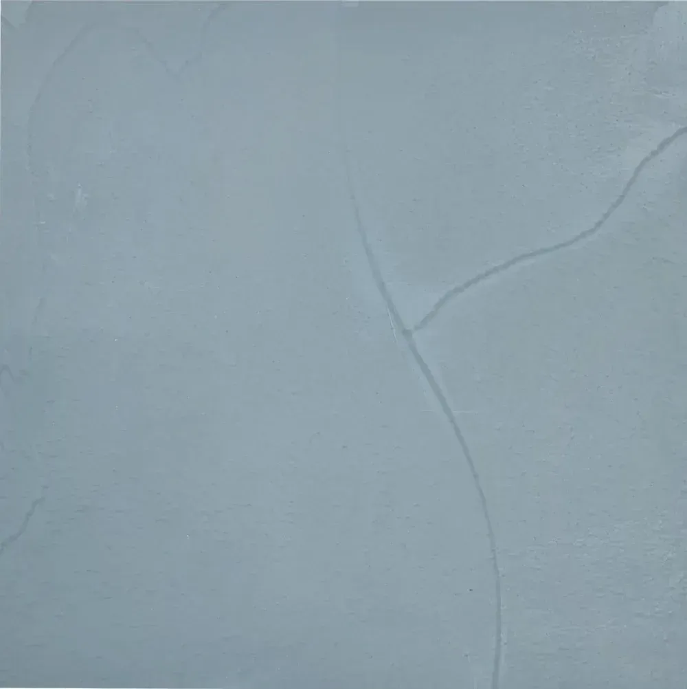 Pale blue textured surface with a subtle crack running diagonally across the right side.