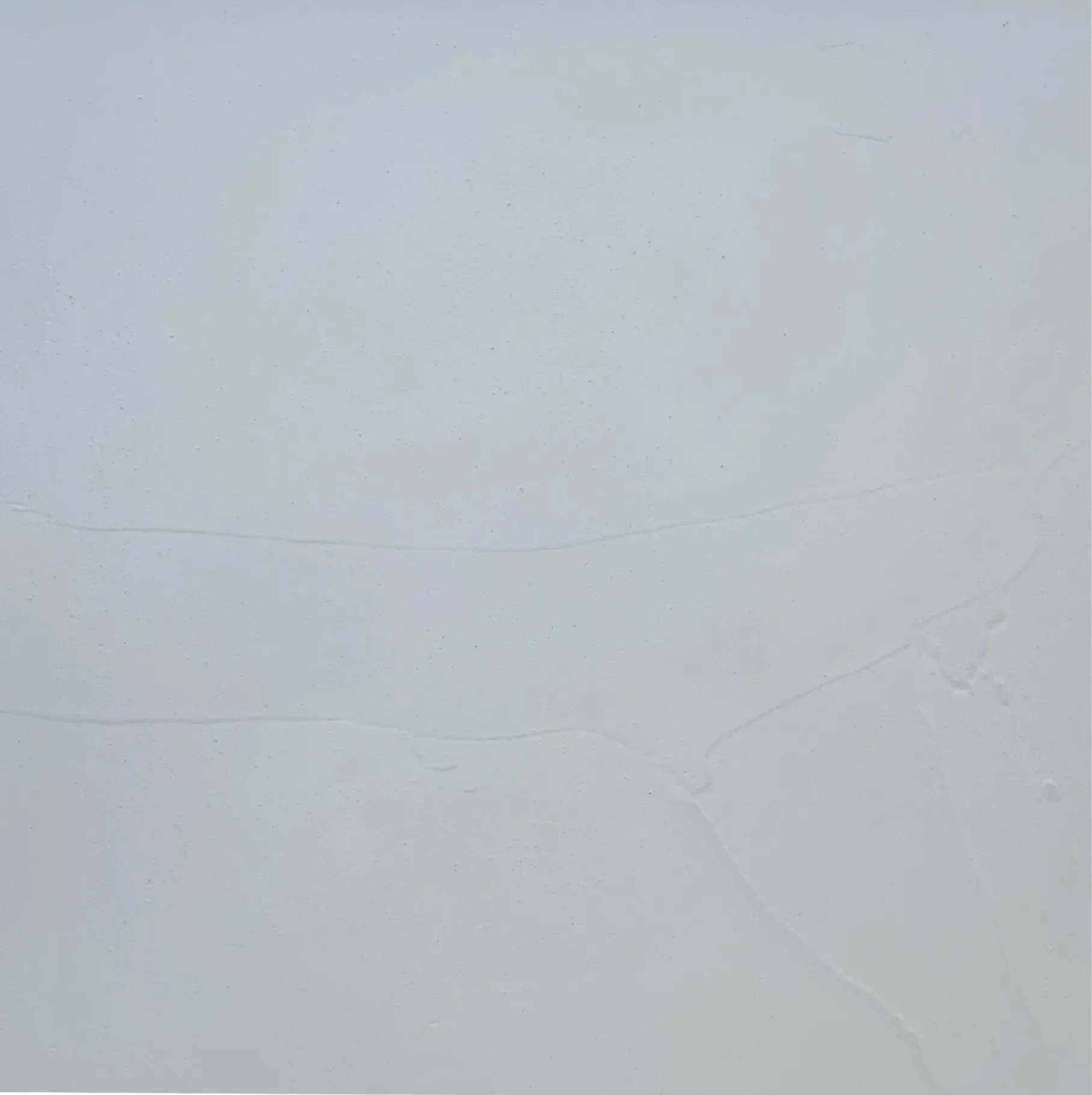 Light gray, textured rectangular surface with faint horizontal lines.