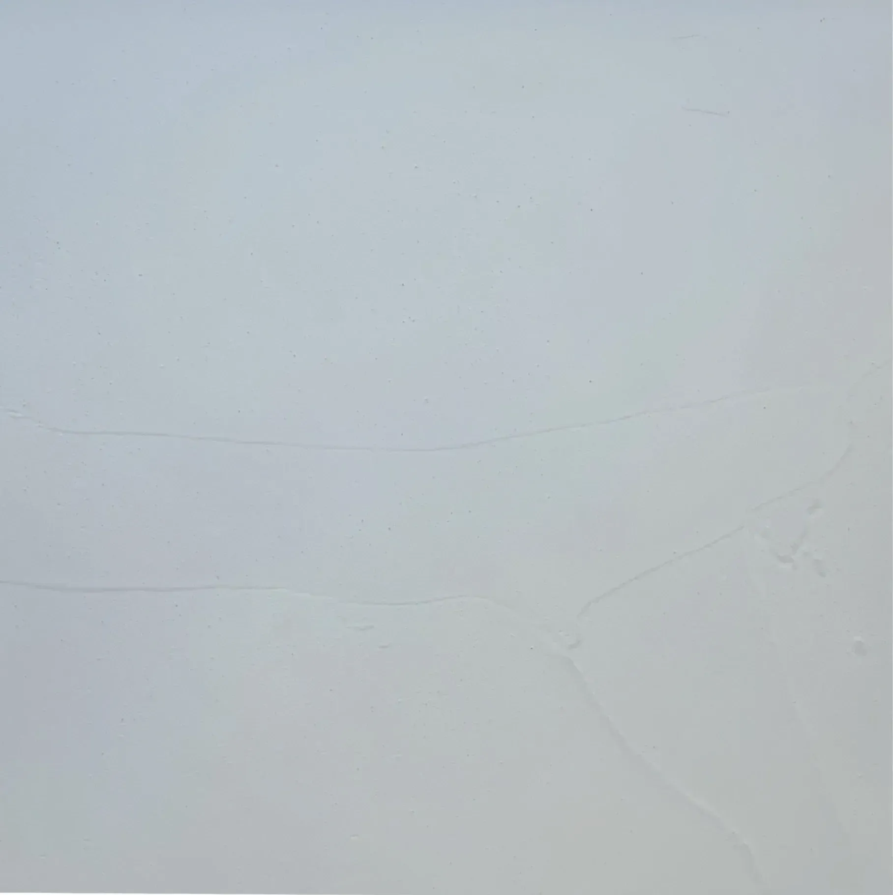 Light gray, textured rectangular surface with faint horizontal lines.