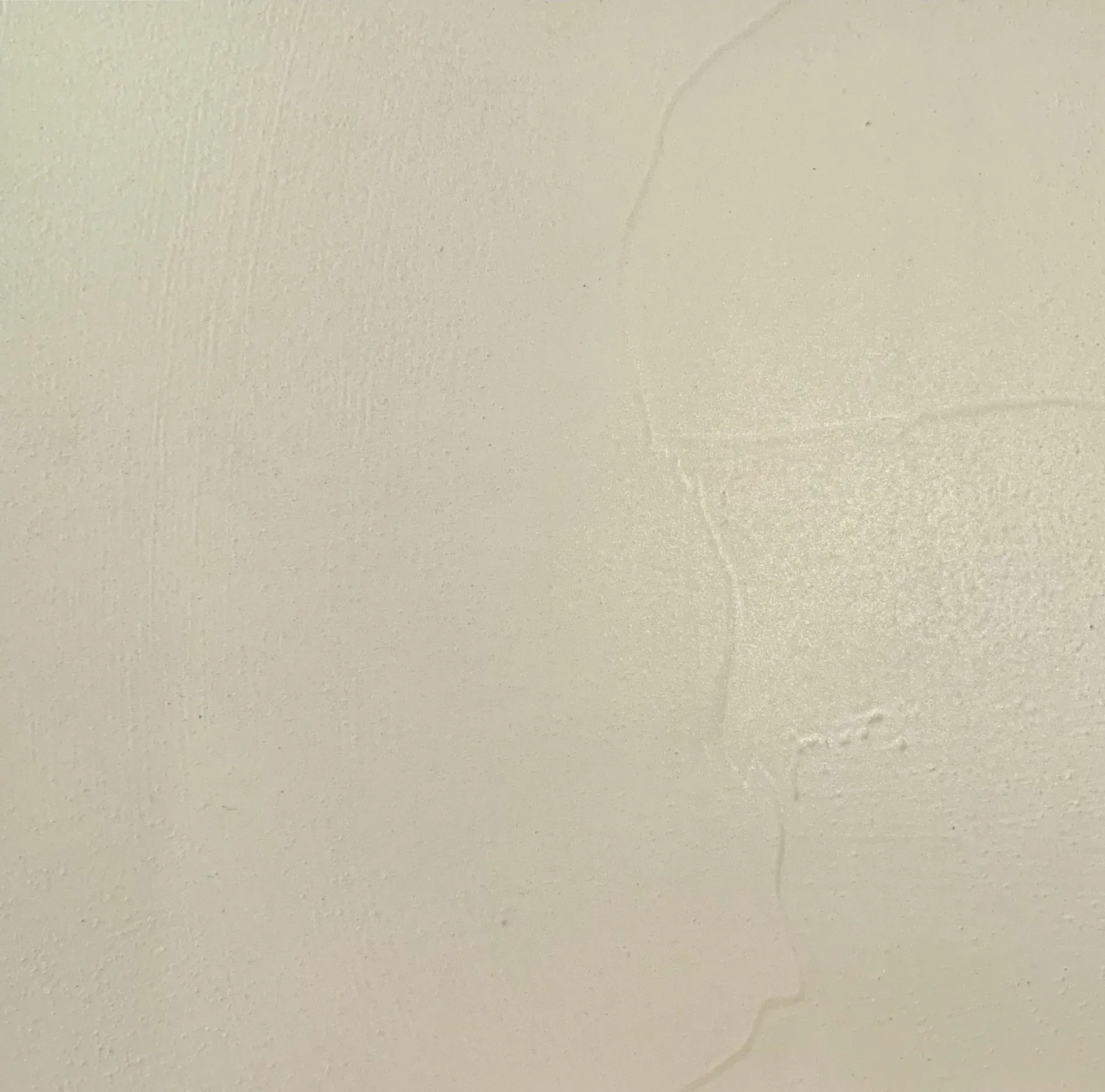 Beige wall with textured surface and visible imperfections.