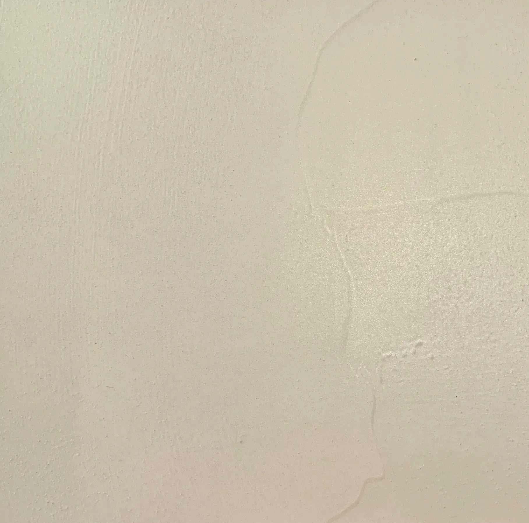 Beige wall with textured surface and visible imperfections.