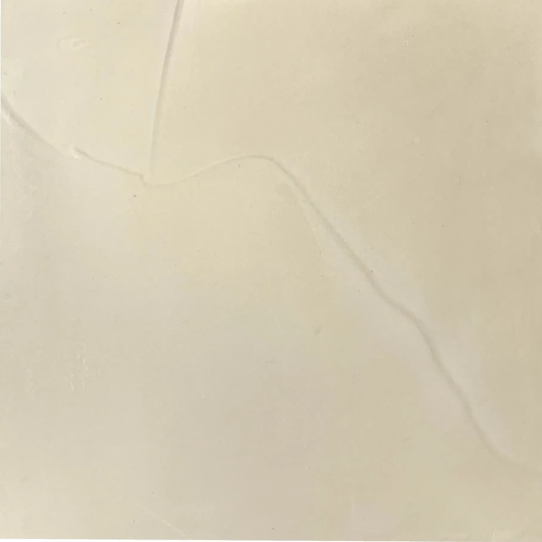 Cream-colored square tile with a faint diagonal gray vein.