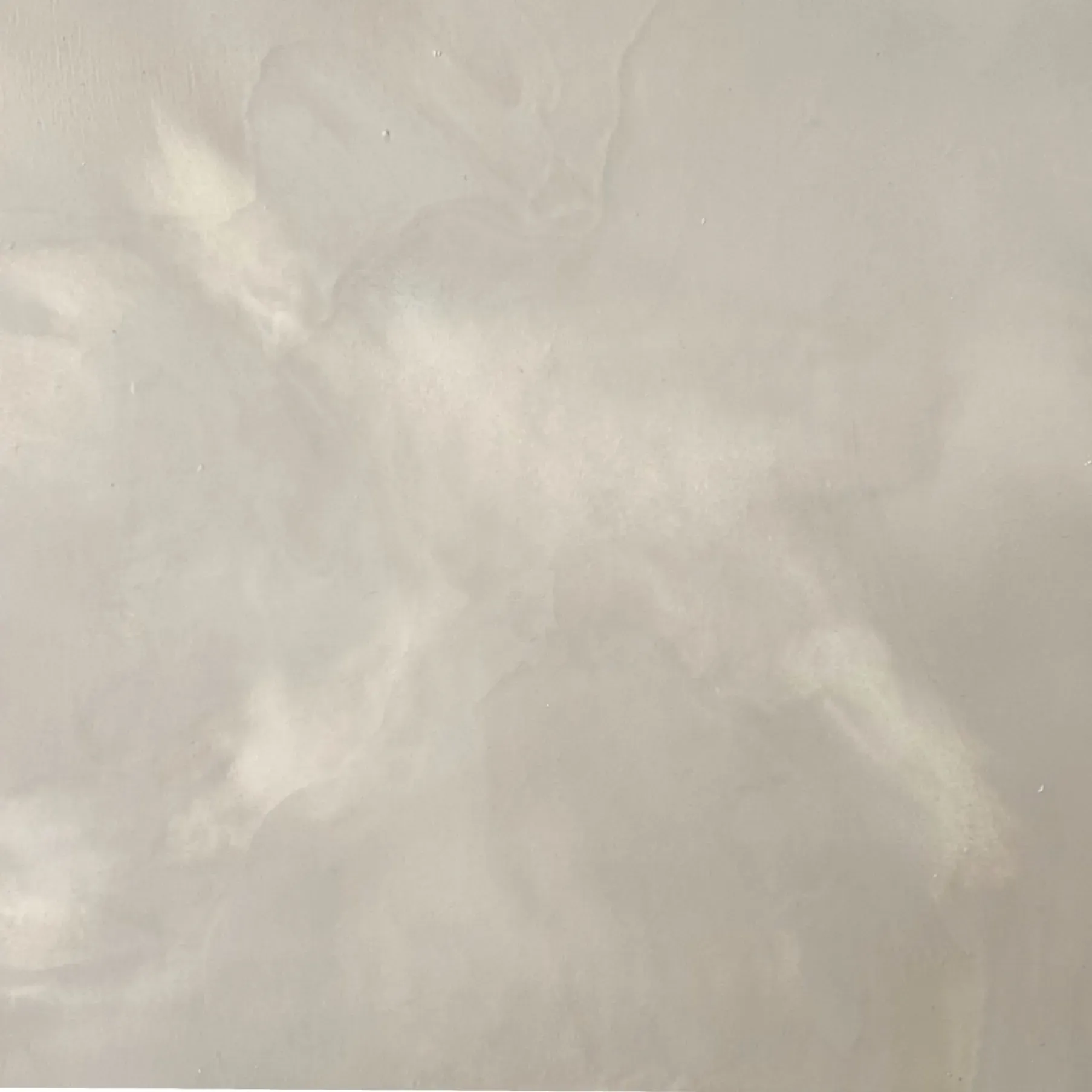Off-white, textured surface with swirling light and dark areas.