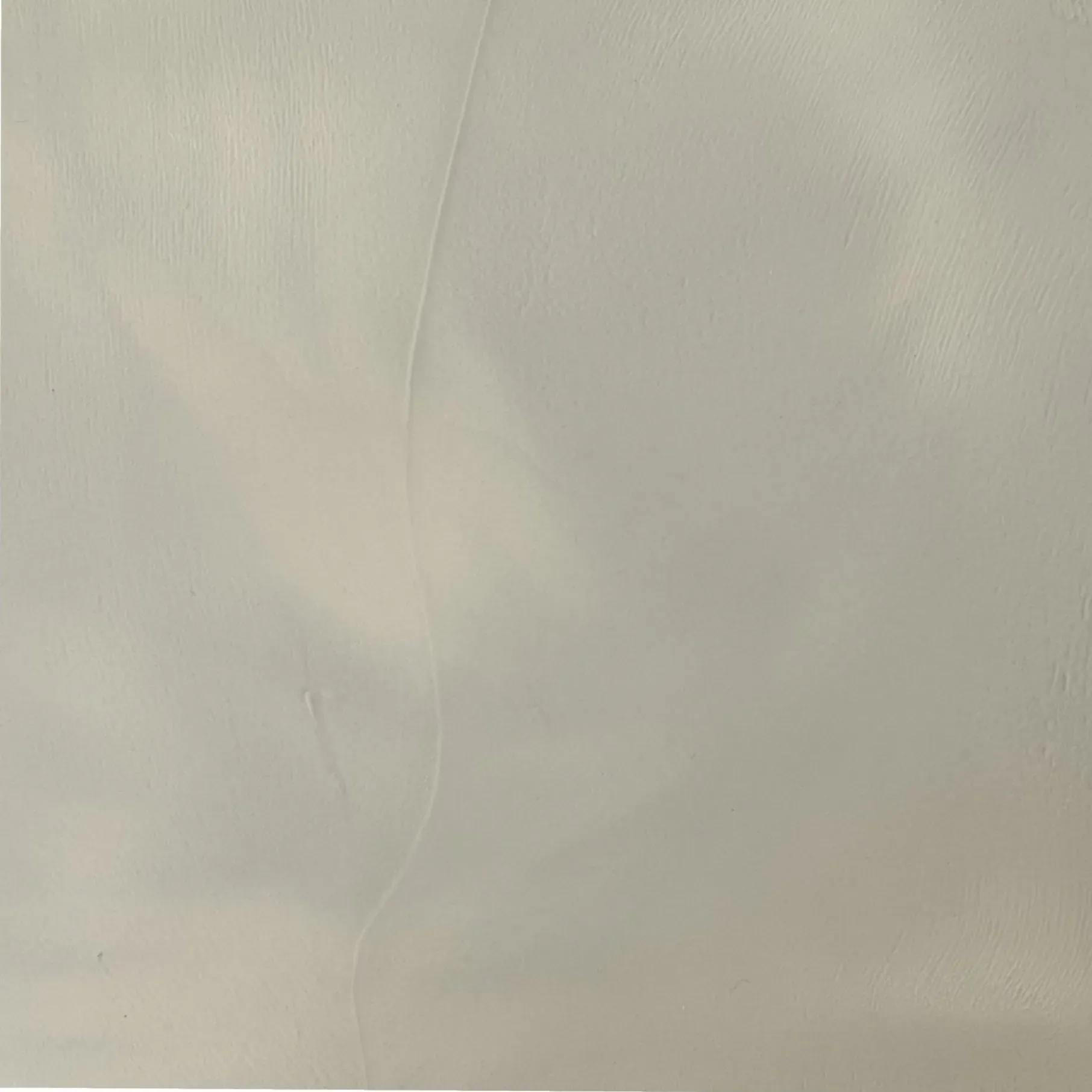 Textured pale gray wall surface with faint variations.