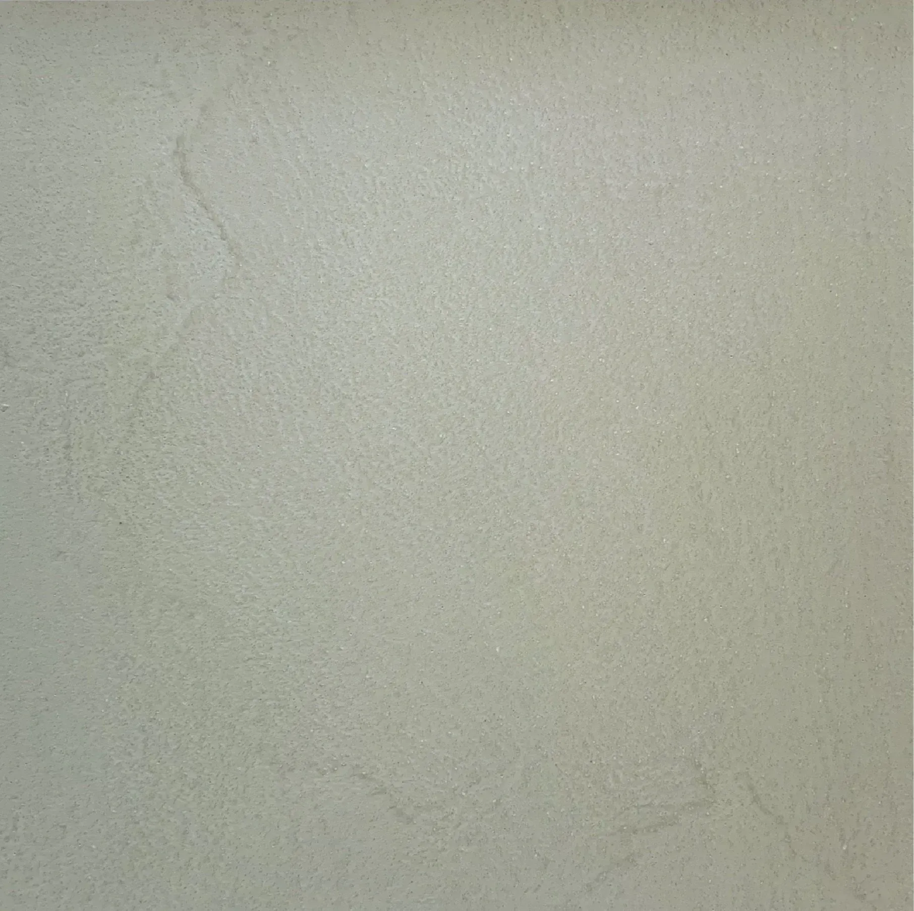 Plain light gray textured wall with faint surface marks