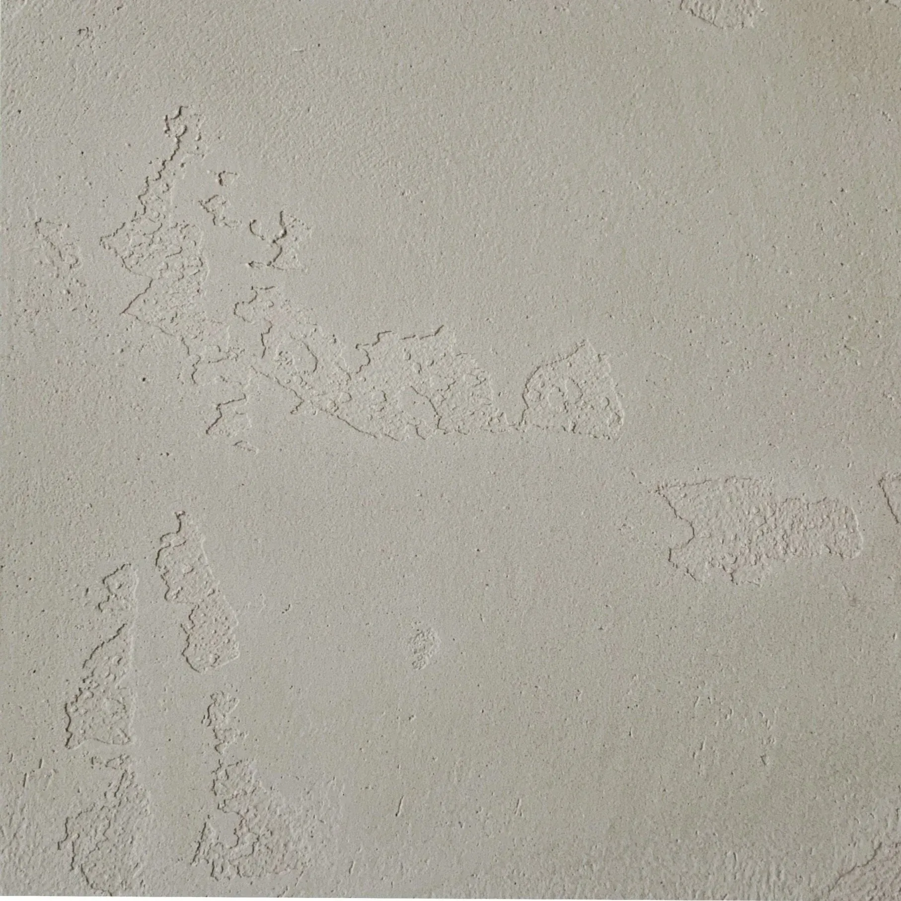 Textured, light gray wall with rough, irregular patterns.