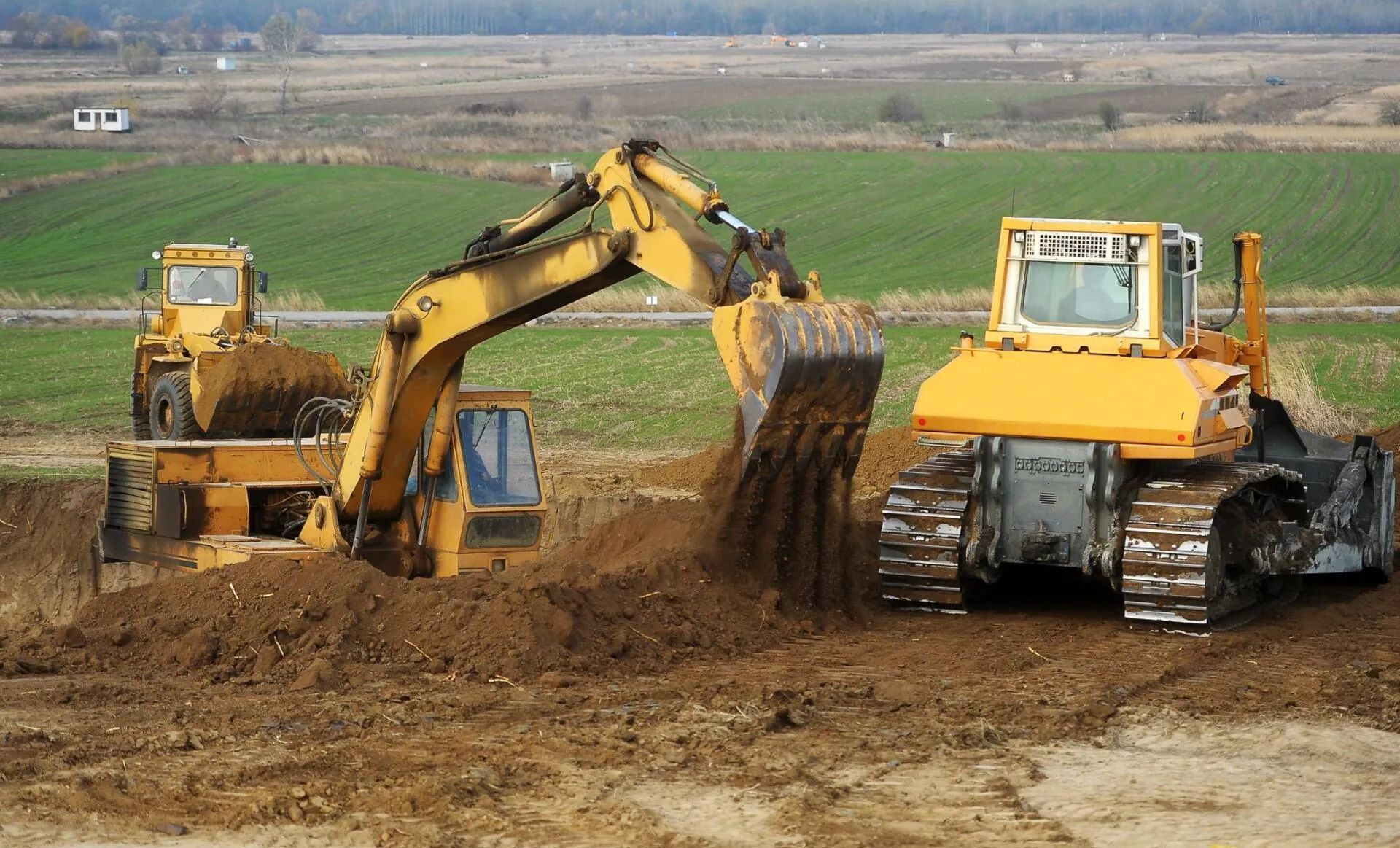 2 excavators excavating land