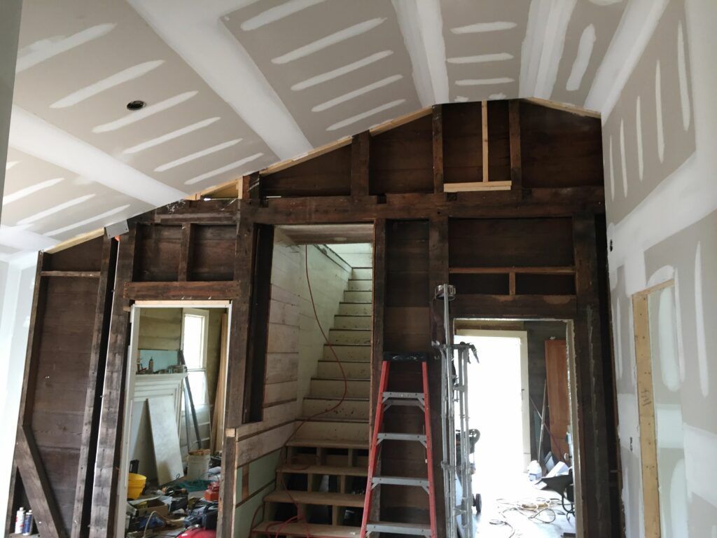 A ladder is in the middle of a house under construction