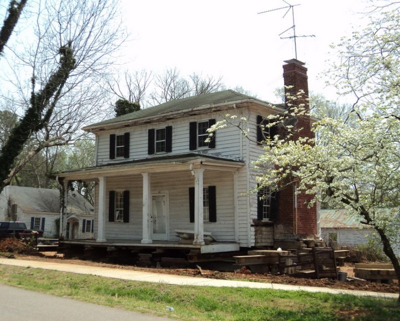 A white house with black shutters and a chimney
