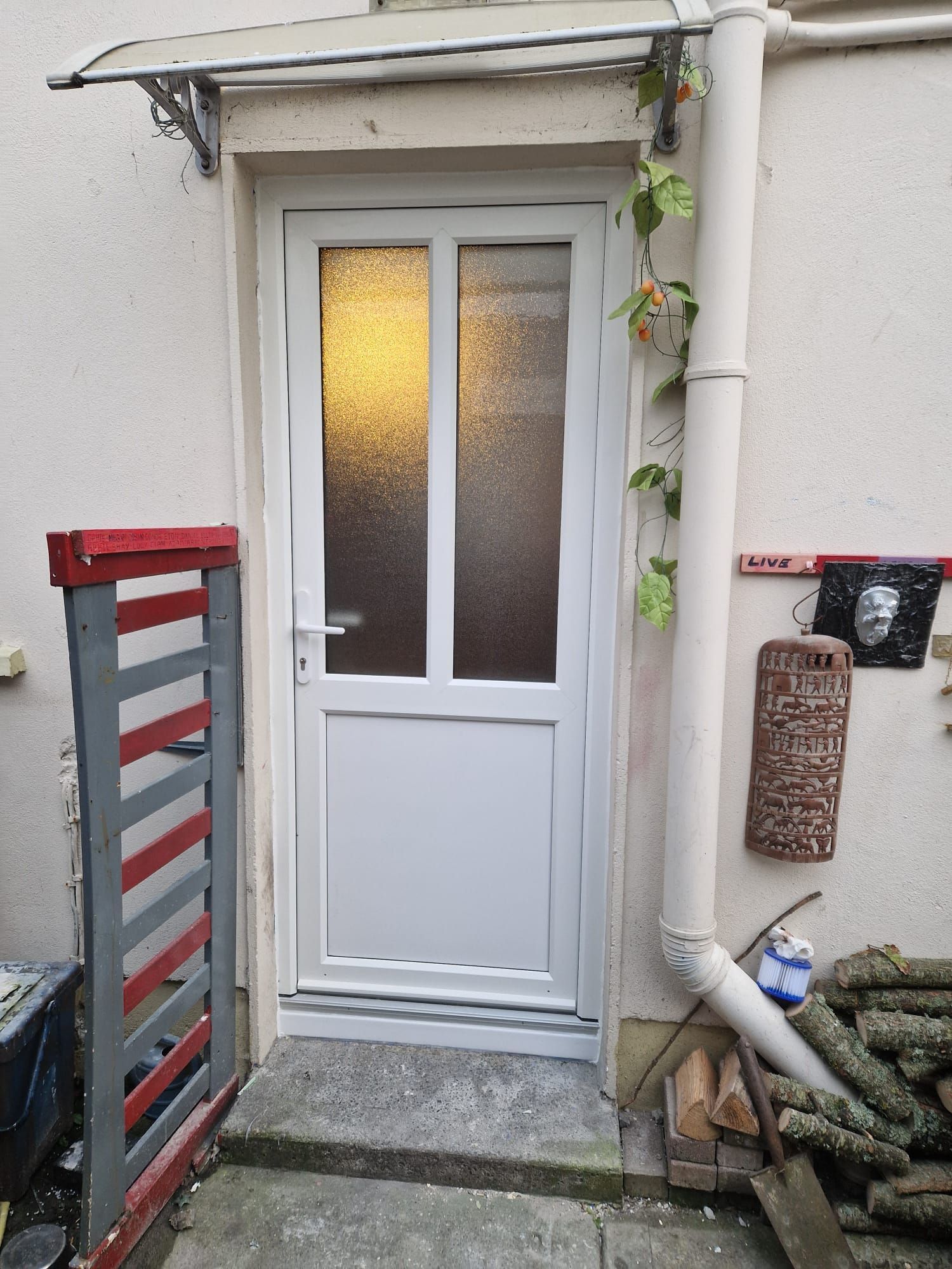 A white door with a canopy over it is on the side of a building.