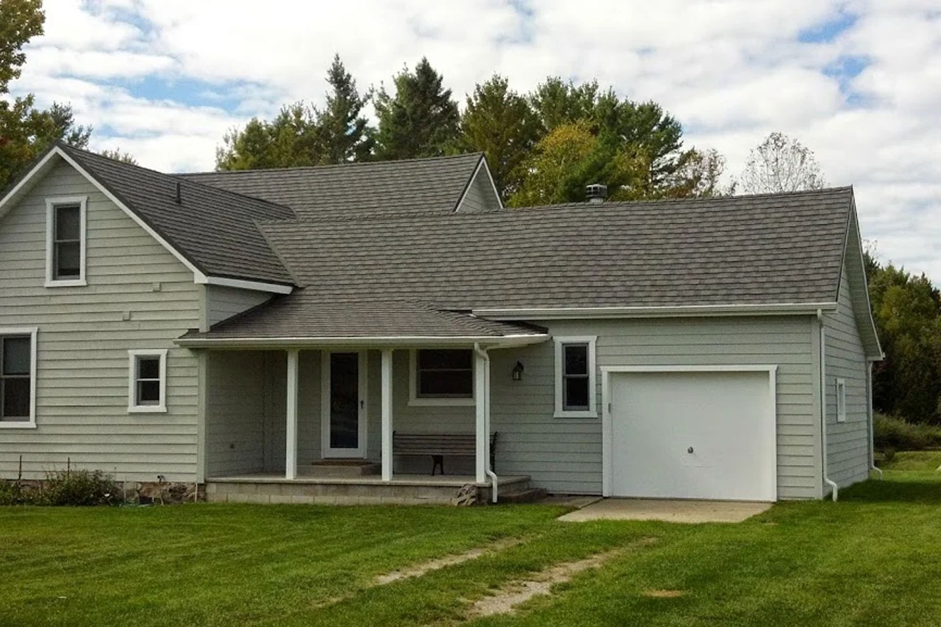 A house with a gray roof and a white garage door