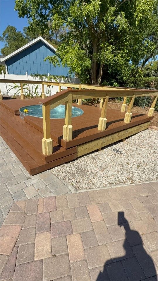 A wooden deck with a hot tub on top of it.