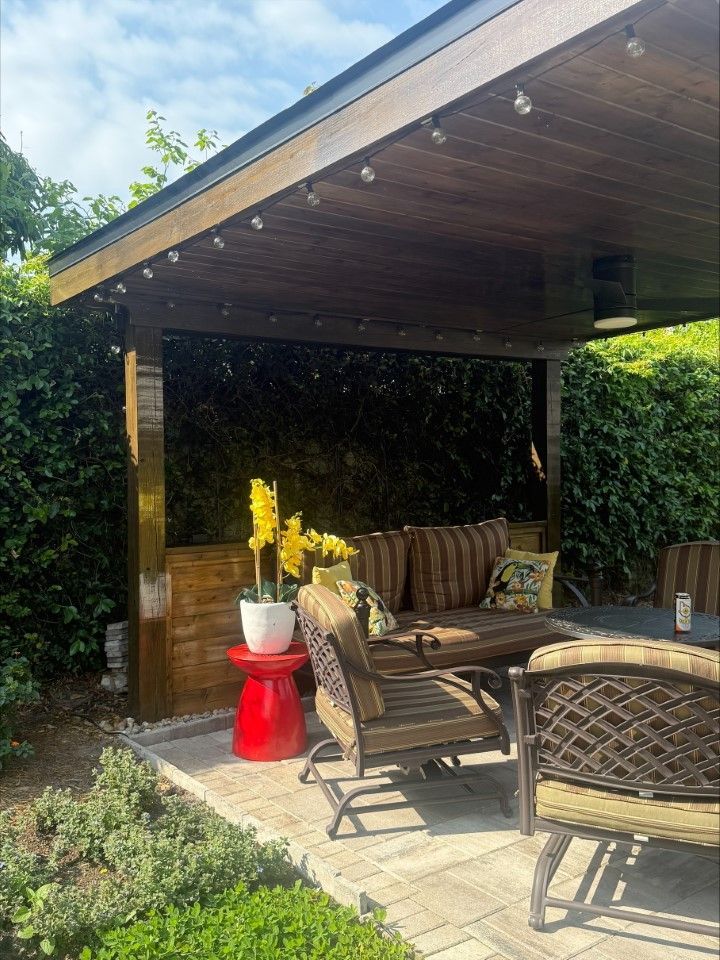 A patio with a table and chairs under a canopy.