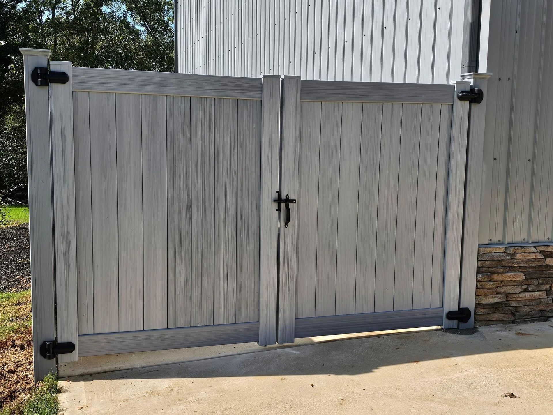 A white wooden gate with black hinges and a cross on it