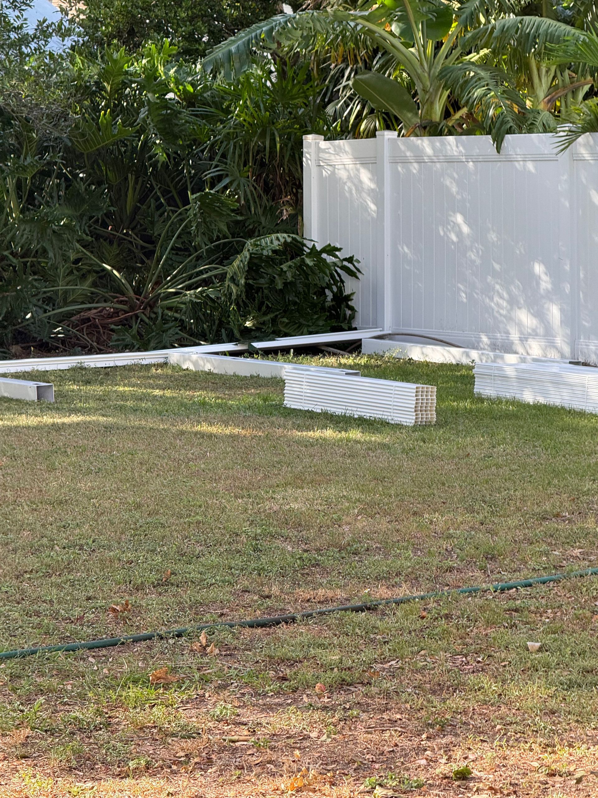 A large lawn with a white fence in the background.