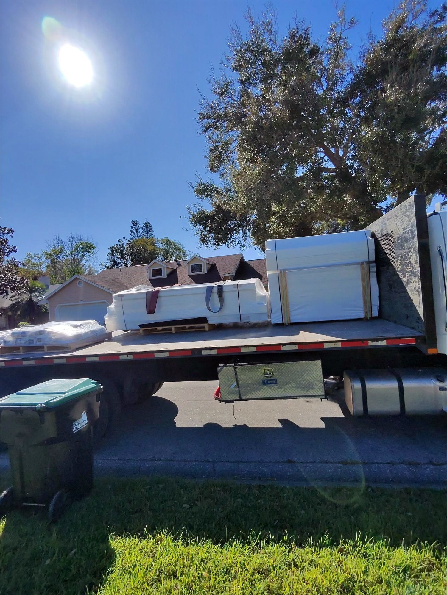 A tow truck is carrying a lot of furniture on the back of it.