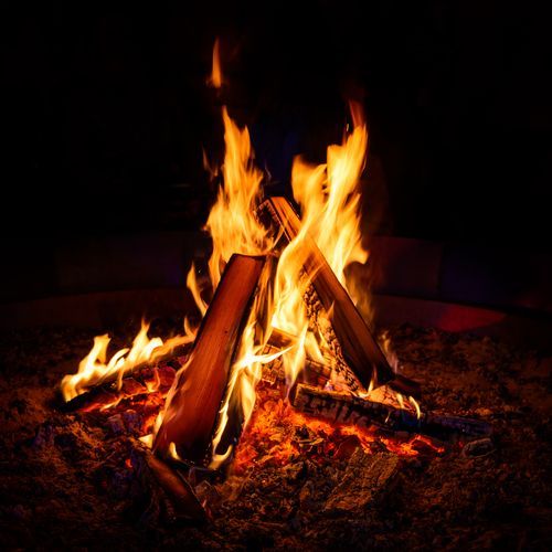 A campfire is lit up in the dark