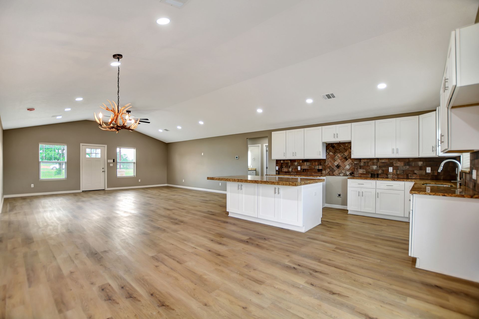 Bright kitchen with white cabinets, island, and wooden floors.