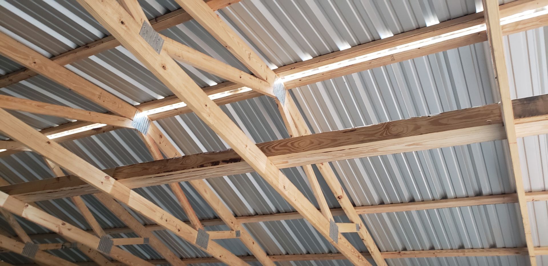 Wooden roof structure with corrugated metal roofing.