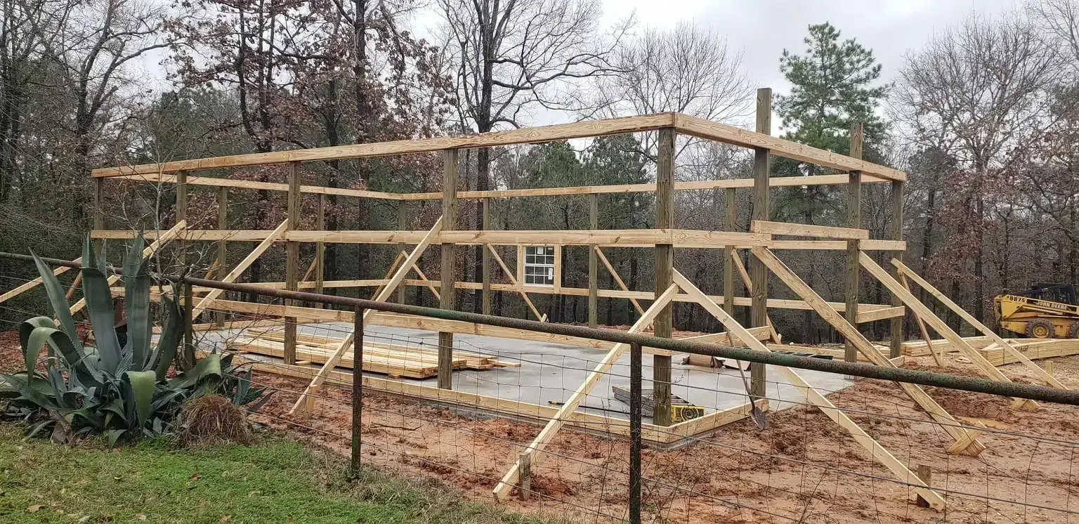 A wooden structure is being built in the middle of a forest.