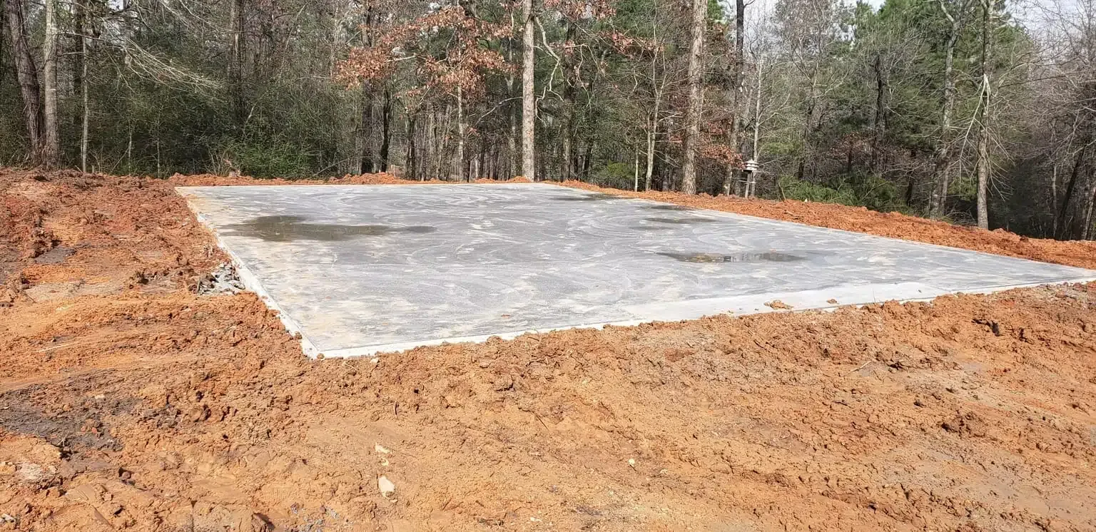 A large concrete slab is sitting in the middle of a dirt field.