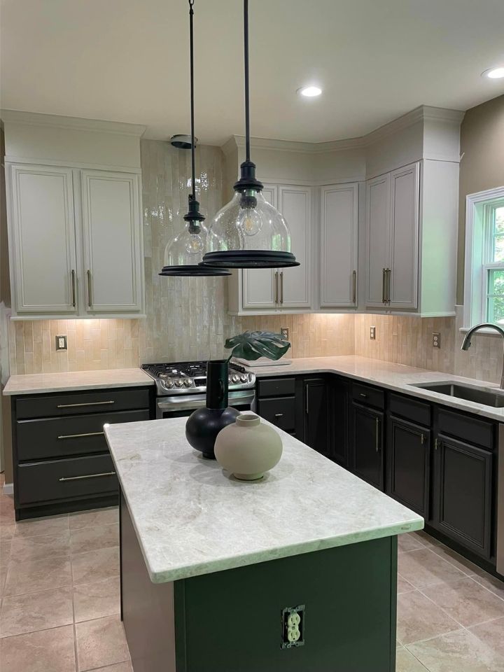 Modern kitchen with dark cabinets, white countertops, central island, and pendant lights