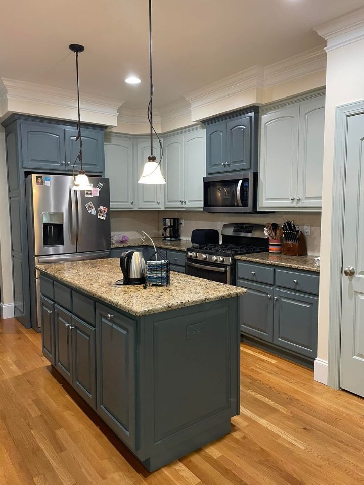 Modern kitchen with gray cabinets, granite island, stainless appliances, and hardwood floors