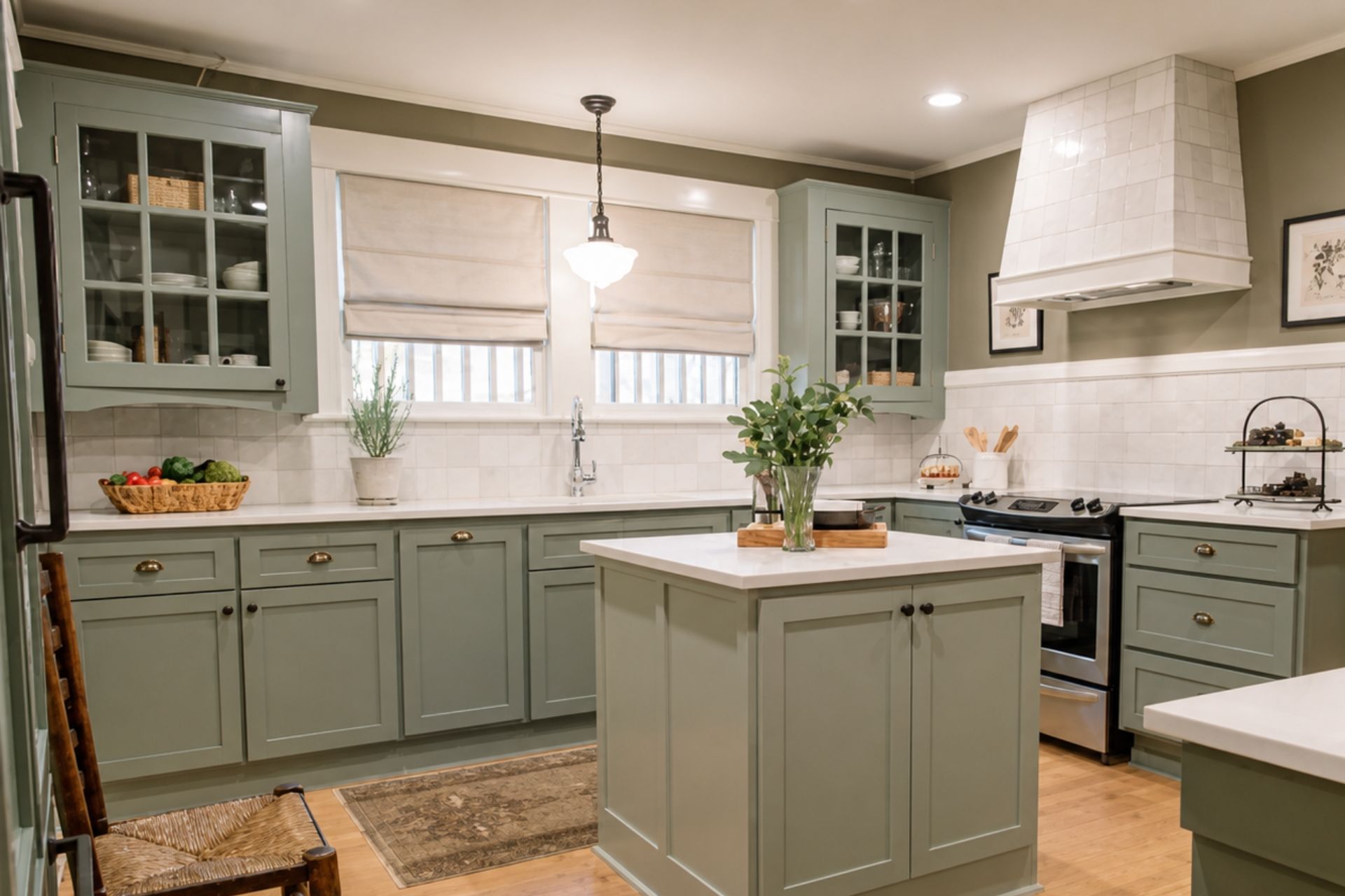 Bright kitchen with gray cabinets, white countertops, island, and hanging pendant lights.