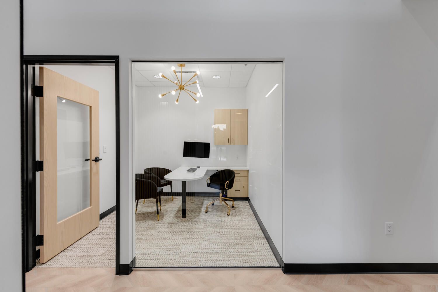 a small office with a desk , chairs and a computer .