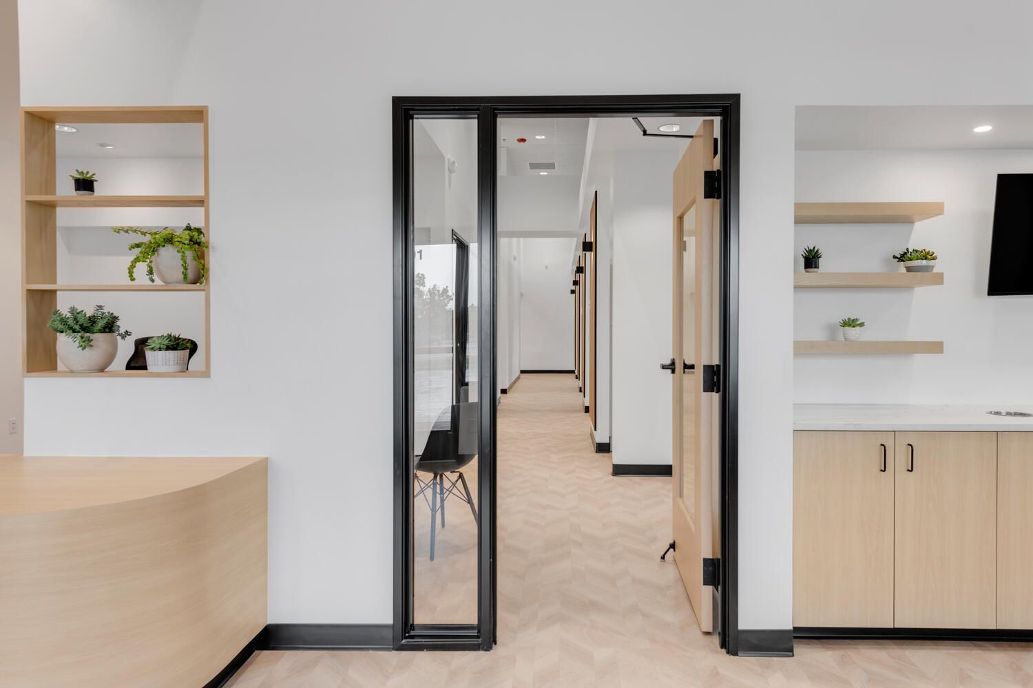 a room with a sliding glass door leading to a hallway .